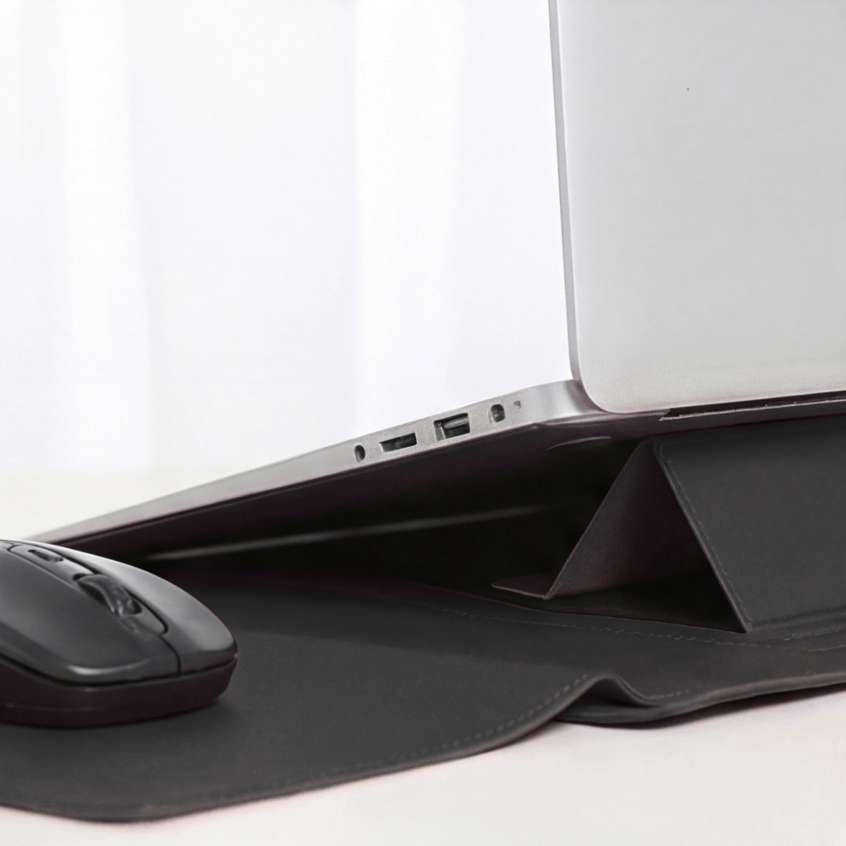 Black laptop sleeve with side ports visible and built-in stand folded down